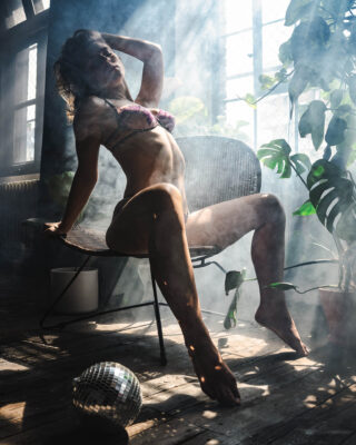 Fotografia powstała podczas warsztatów organizowanych przez Joanka Love. Fotografia kobieca Wrocław, zmysłowy portret na krześle w promieniach okna, dym w powietrzu, rośliny i loftowe światło.